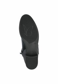 Suela de zapato negra con una superficie de goma suave y un diseño de mariposa, además de un patrón de agarre texturizado; el tacón incluye un pequeño acento de color.