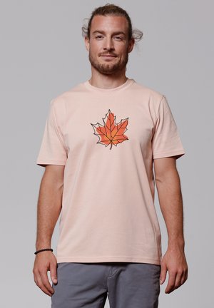 Helles pinkes T-Shirt mit kurzen Ärmeln und einem geometrischen orangefarbenen Ahornblatt-Logo auf der Brust, aus weichem Baumwollmaterial gefertigt.