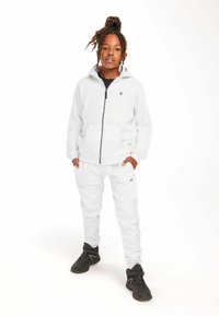 Gray zip-up hoodie and matching sweatpants made of fleece material, featuring front pockets and a logo on the chest and pant.