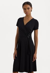 Zwarte wikkel jurk met korte mouwen, V-halslijn, zijdetail met een ronde accent, en een vloeiende rok die tot onder de knie valt.