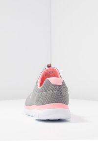 Szare siateczkowe sneakersy z różową piętą i wewnętrzną wyściółką, z białą podeszwą. Posiadają pętelkę z tyłu dla łatwego zakładania.