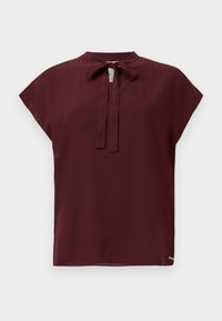 Burgunderfarget bluse med høy hals og knytedetalj, korte ermer med cap, glatt tekstur og en liten logoaccents på kanten.