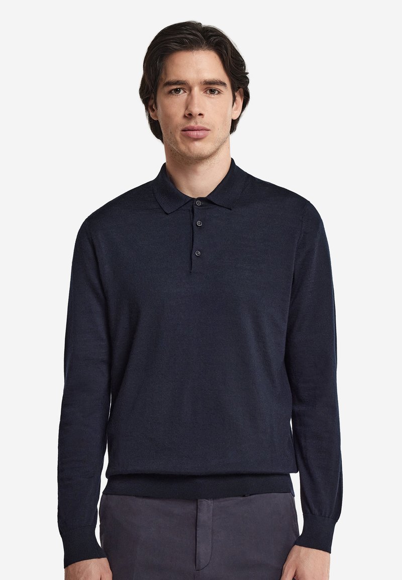 Marinblå långärmad polo skjorta i mjukt tyg, med krage, treknapplåda och ribbade muddar. Enkelt design.