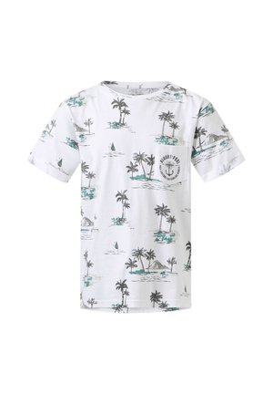 Garçon debout, main sur la nuque, portant un t-shirt blanc à motif de palmiers, un jean bleu et des baskets blanches avec des rayures vertes.