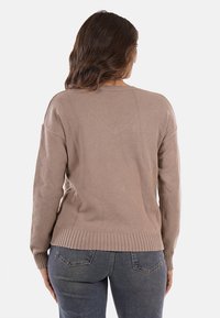 Maglione lavorato a maglia marrone chiaro con orlo e polsini a coste. Presenta una vestibilità comoda e una texture liscia, mostrato da dietro.