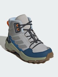 Šedé hikingové boty s horní částí z textilu, modrými a zelenými akcenty a černými tkaničkami. Mají robustní vzorek podrážky pro lepší přilnavost.