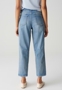 Lichtblauwe denim jeans met een relaxte fit, vijf zakken en subtiele stikdetails. De zoom is omgeslagen met een recht gesneden silhouet.