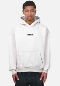 Sweatshirt blanc avec une capuche, arborant un logo noir "DPSZE" sur la poitrine, des poignets côtelés et une poche avant. Tissu au toucher doux.