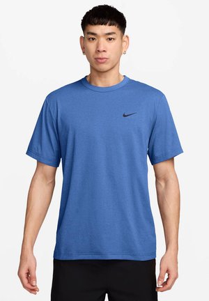 Blå kortærmet Nike T-shirt lavet af blødt stof, med et sort logo på brystet, rund hals og løs pasform.