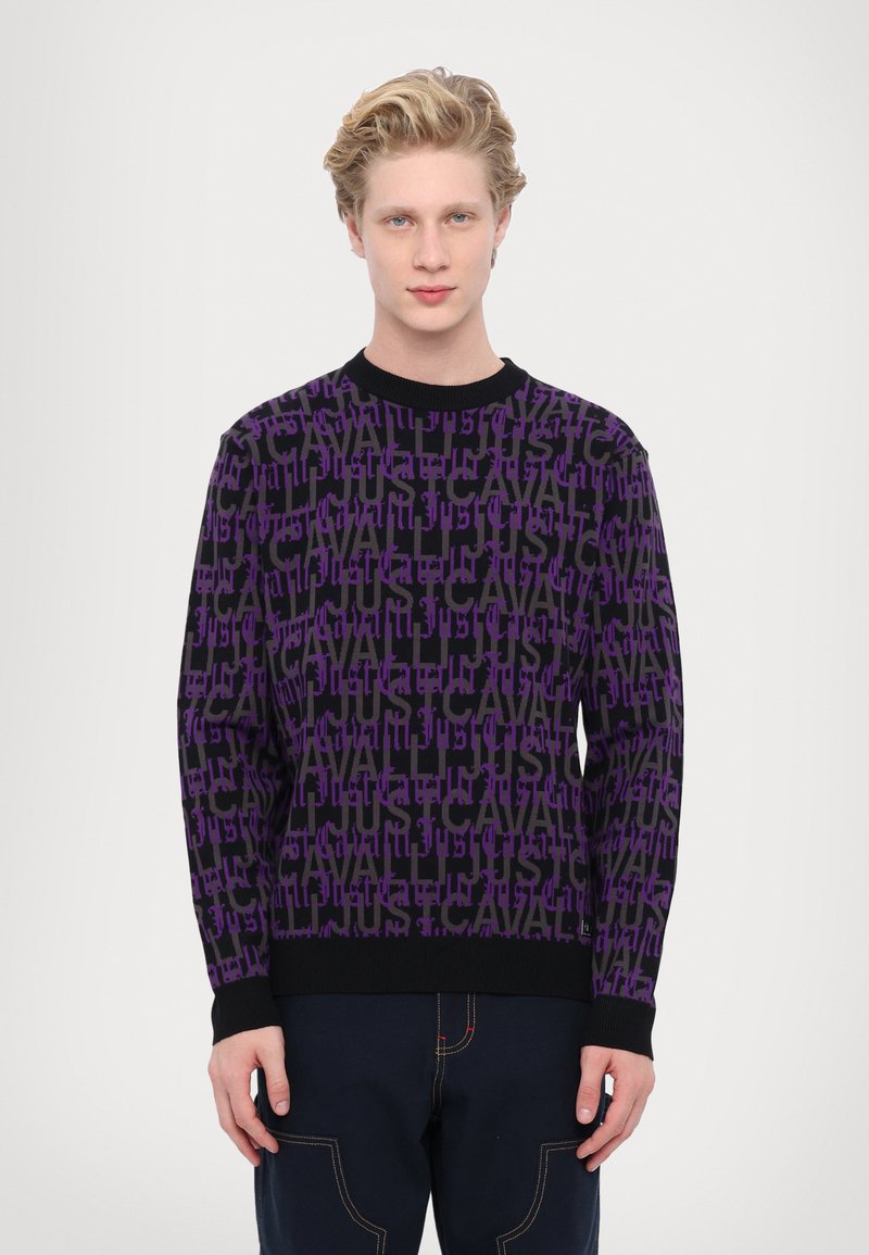Purple and black patterned sweater featuring a repeated text design, round neckline, and ribbed cuffs and hem. Cotton material.