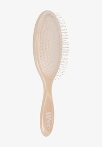 Våt børste med et lyserosa plastgrep og oval hode, med fleksible børster arrangert i et rutenettmønster.