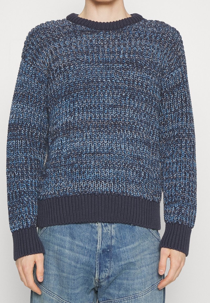 Námořnickomodrý pletený svetr s texturovaným vzorem a světle modrými akcenty, žebrovanými manžetami a lemem pro těsný střih.