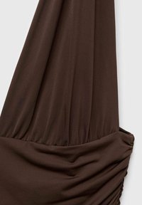 Robe brune en tissu doux et tordu ; présente une texture froncée et un design drapé ; transition sans couture entre le haut et la jupe.