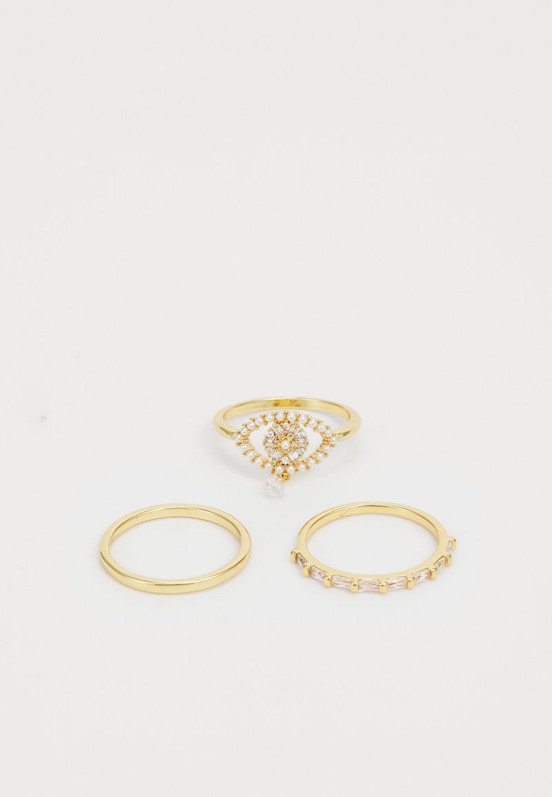 Trīs gredzenu komplekts: viens zelta gredzens ar dekoratīvām dārgakmeņu akcentiem un divi parasti zelta gredzeni. Gludas virsmas, atšķirīgi dizaini un formas.