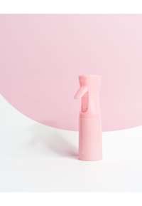 Bouteille pulvérisateur rose avec un design incurvé, spray à gâchette et chambre transparente. Fabriquée en plastique, présente un logo sur le côté.