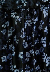 Zwart stof met een geraffineerde naad, met een patroon van kleine lichtblauwe en lichtpaarse bloemenclusters.