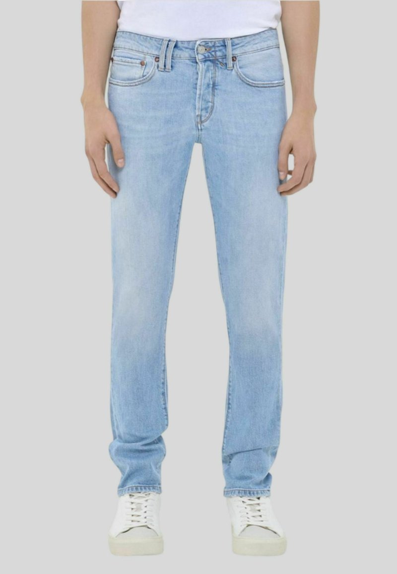 Jeans in denim blu chiaro con taglio dritto, dotati di cinque tasche, chiusura con bottone e leggero sbiadimento. Indossati con sneakers bianche.