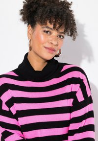 Mustapinkki raidallinen neulepaita, jossa on korkea ribbireunus. Valmistettu paksusta neuleesta, jossa on pitkät hihat ja rento istuvuus.