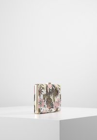 Bolso de mano con estampado floral en tonos rosa y verde, tela texturizada, cierre metálico y detalles dorados. Forma rectangular compacta.