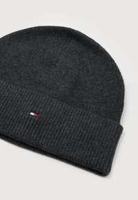 Berretto a coste di colore grigio scuro con risvolto e un piccolo logo rettangolare rosso, bianco e blu al centro del risvolto.