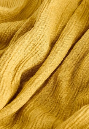 Textured, golden-yellow fabric with soft, ribbed patterns. Material appears lightweight and slightly sheer, with a smooth finish.
