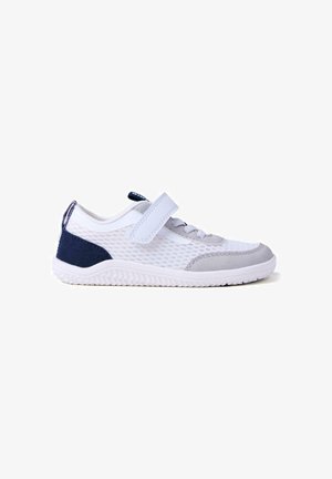 Zapatilla deportiva de malla blanca y gris con una tira de velcro, suela de goma texturizada y detalles en azul marino en el talón y el lateral. Diseño ligero.