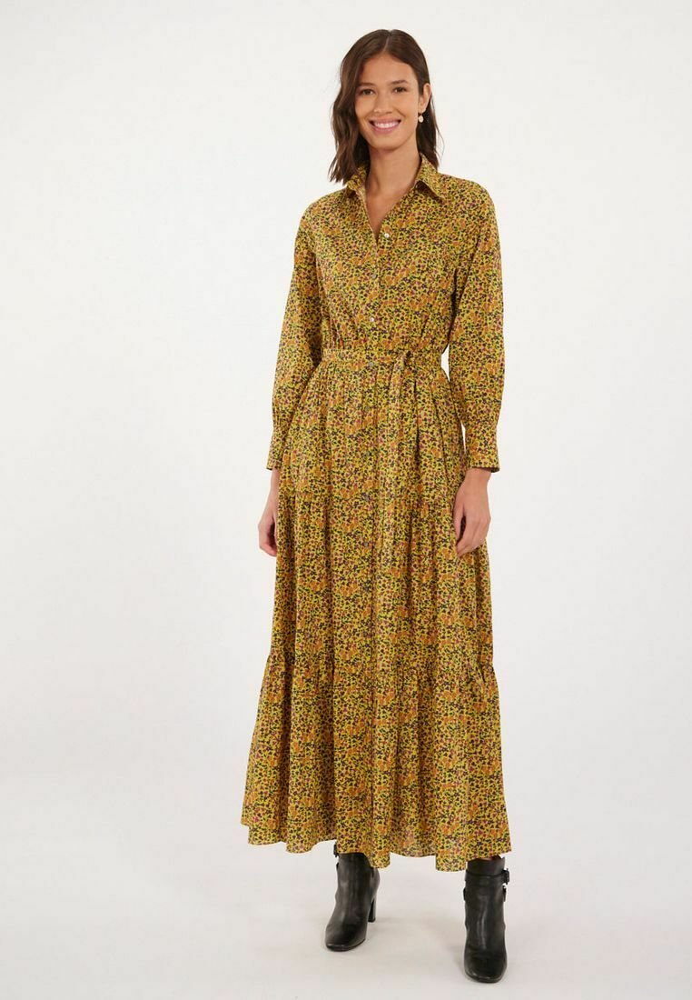 Robe longue à boutons avec une base jaune et un motif floral en vert et rouge. Elle a une taille cintrée et une jupe à volants.