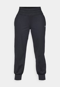 Black high-waisted jogger pants with elastic cuffs and a small white logo on the right thigh against a white background.