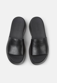 Sandales à glisser en cuir noir avec une large sangle lisse et une semelle rembourrée. Design minimaliste avec une finition mate et un logo embossé sur la semelle intérieure.