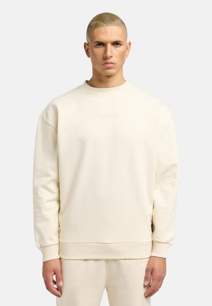 Felpa color crema con un fit rilassato, dotata di polsini e orlo a costine, logo ricamato sul petto e una morbida texture in cotone.