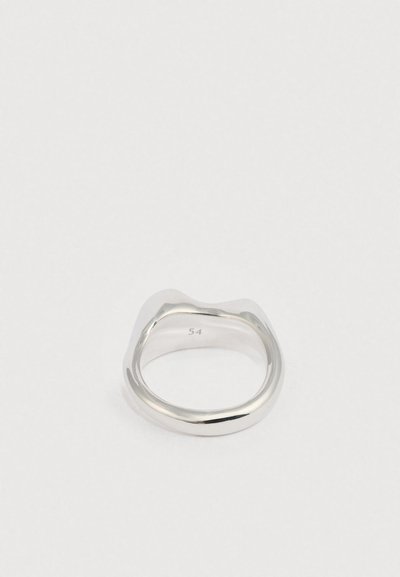 Ezüst gyűrű sima, hullámos kialakítással és polírozott felülettel. Kerekített szalaggal rendelkezik, a belső felületén pedig "54" méretgravírozás található.