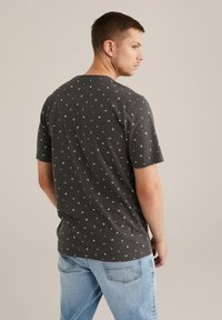 Grå kortærmet t-shirt med et spredt hvidt geometrisk mønster. Fremstillet af bomuld, med rund halsudskæring og en afslappet pasform.