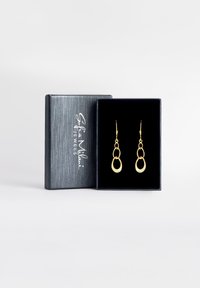 Goldene Tropfohrringe mit zwei miteinander verbundenen ovalen Formen, untergebracht in einem schwarzen Samt-Innenraum einer silbermusterweiten Box.