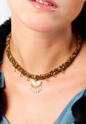 Perlen-Halskette in goldbraunen Tönen, mit einem fächerförmigen goldenen Anhänger, der hängende Akzente und ein strukturiertes geflochtenes Design aufweist.