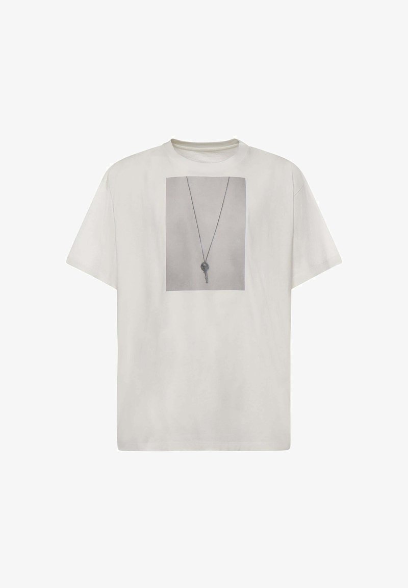 T-shirt blanc à manches courtes avec une photo en noir et blanc d'une clé sur un collier imprimée au centre à l'avant.