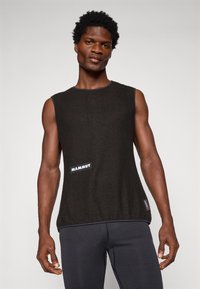 Top negru fără mâneci, cu țesătură texturată, decolteu rotund, margine albastră și un logo alb "Mammut" pe față. Se leagănă lejer.