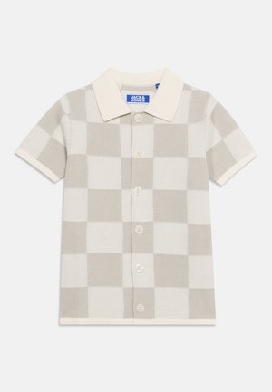 Camisa de manga corta a cuadros beige y blanca con cuello crema y etiqueta "Jack & Jones" en el interior del cuello.