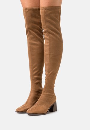 Braune Wildleder-Stiefel über dem Knie mit quadratischer Zehenform und einem klobigen Absatz. Die Oberfläche ist glatt mit sichtbaren Nähten an den Seiten.