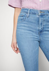 Ljust blå denimjeans med en slim fit, med hög midja, standard fem fickor och diskreta stygn detaljer.
