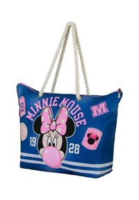 Bolsa de mano azul con asas de cuerda que presenta un gráfico de Minnie Mouse, un lazo de lunares y parches. Incluye el texto "Minnie Mouse" y el año 1928.