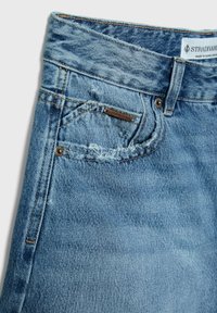 Ljusblå denimjeans med en sliten finish. Funktioner inkluderar en femficksdesign, kontrasterande sömmar och en märkesetikett på bakfickan.
