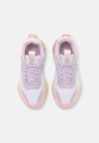 Paire de chaussures de sport violet clair et rose avec semelles blanches, lacets noués, vues de dessus sur un fond blanc uni.