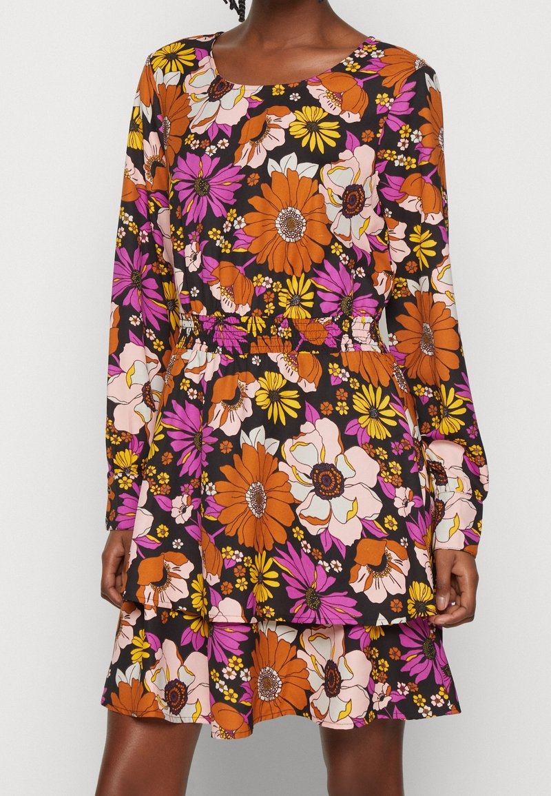 Blumenkleid mit langen Ärmeln, runder Ausschnitt und schwarzem Hintergrund mit leuchtend orangefarbenen, rosa und weißen Blumen. Elastischer Bund.