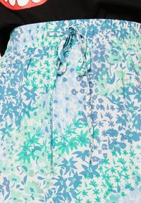 Shorts à motif floral en tissu léger, présentant des tons de bleu et de vert, avec une taille élastique et un cordon de serrage.