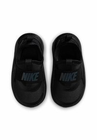 Des chaussures noires Nike à enfiler avec un dessus en mesh texturé, une sangle élastique avec logo, et un design à bout arrondi. Semelle extérieure en caoutchouc lisse avec adhérence.