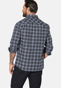 Kariertes Hemd in Marineblau, Blau und Gelbtönen; lange Ärmel aufgerollt; strukturierter Stoff; Rückansicht mit Yoke- und Nähdetails.