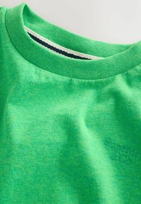 Sweat-shirt vert vif à col rond avec col côtelé et logo brodé discret "Superdry & Co" sur la poitrine.