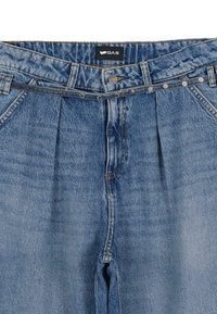 Jeans in denim blu con vita alta, pieghe frontali e chiusura a bottone. La vita è decorata con borchie.