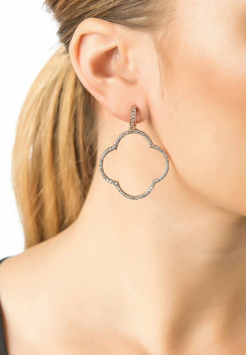 Rose gold hoop earrings feature a cloud shape, adorned with sparkling clear crystals along the edge, hanging from a slender vertical post.
