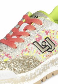 Sneaker luccicante con tomaia multicolore a macchie, lacci rosa, logo metallico e dettagli in oro testurizzati sulla suola.